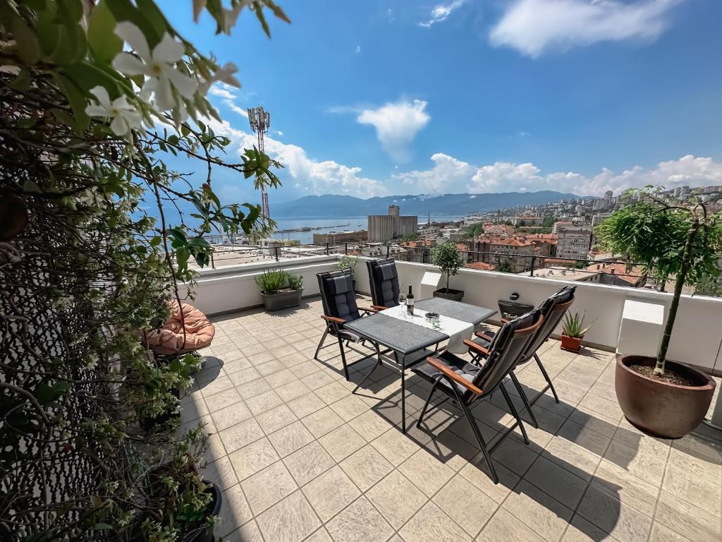 a patio with a table and chairs on a roof at 105m2 Penthouse Sea View Rijeka with FREE GARAGE PARKING in Rijeka