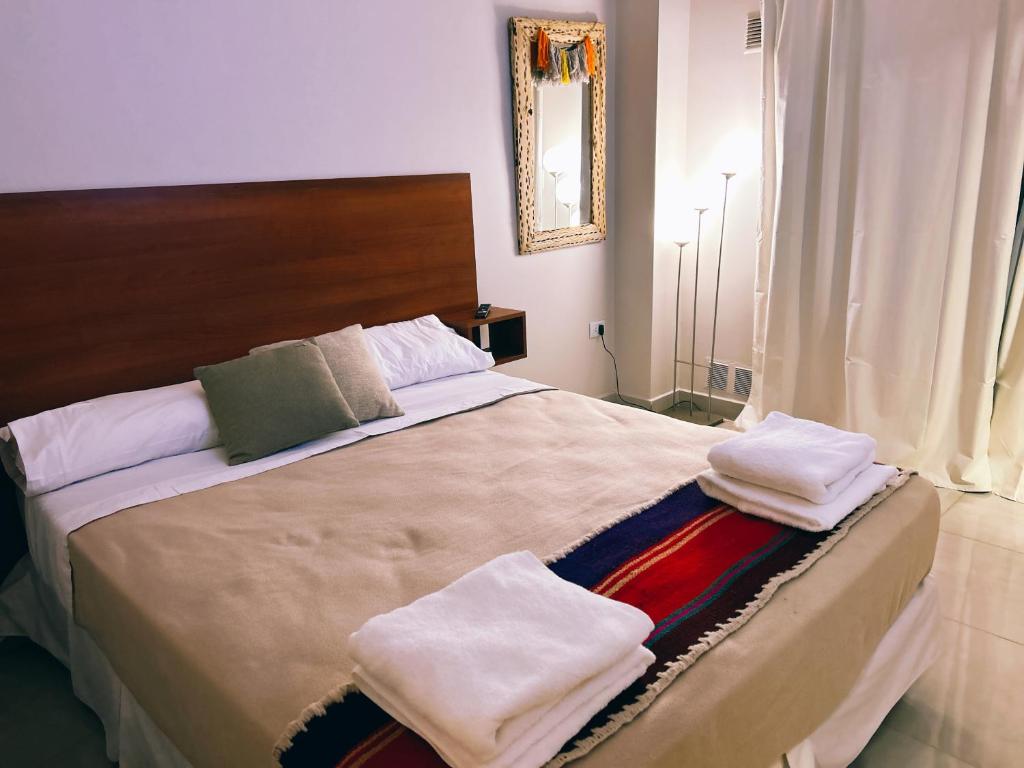 a bedroom with a large bed with towels on it at Aires del Norte Apart in San Miguel de Tucumán