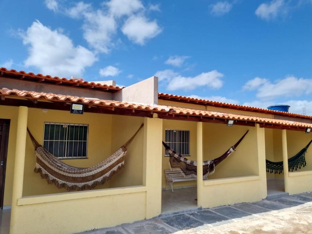 two hammocks on the side of a house at Pousada Talismã in Barreirinhas