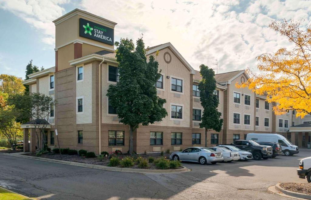 a hotel building with cars parked in a parking lot at Extended Stay America Suites - Detroit - Metropolitan Airport in Romulus