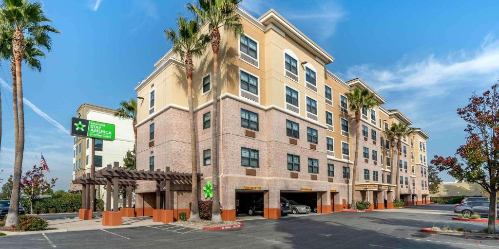 a large building with palm trees in front of a street at Extended Stay America Premier Suites - San Francisco - Belmont in Belmont