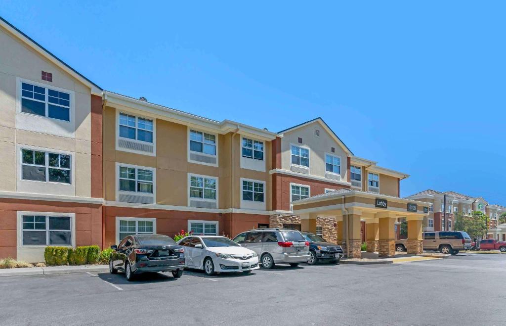 a parking lot with cars parked in front of a building at Extended Stay America Suites - San Jose - Edenvale - North in San Jose