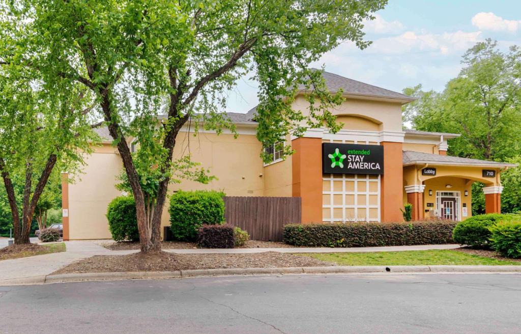 a building with a sign for a hotel at Extended Stay America Select Suites - Charlotte - Airport in Charlotte