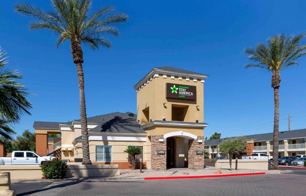 a hotel with palm trees in front of a building at Extended Stay America Suites - Phoenix - Airport - E Oak St in Phoenix