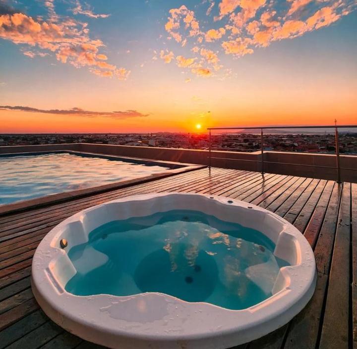 a bath tub on a deck with the sunset in the background at Paradiso Corporate in Cabo Frio