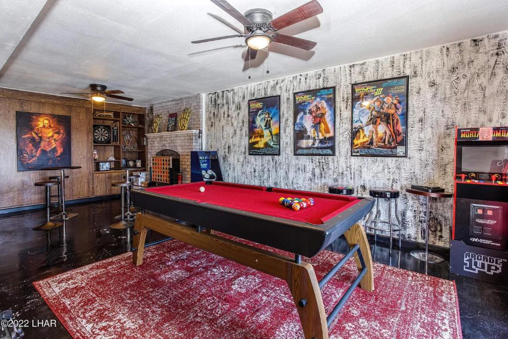 a room with a pool table and a ceiling fan at Horror House- arcade & heated pool! Room for all! in Lake Havasu City