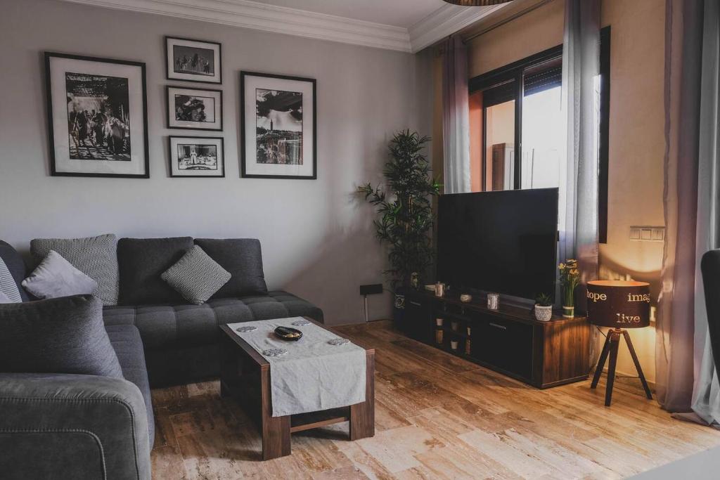 uma sala de estar com um sofá e uma televisão em Magnifiaue appart em Marrakech