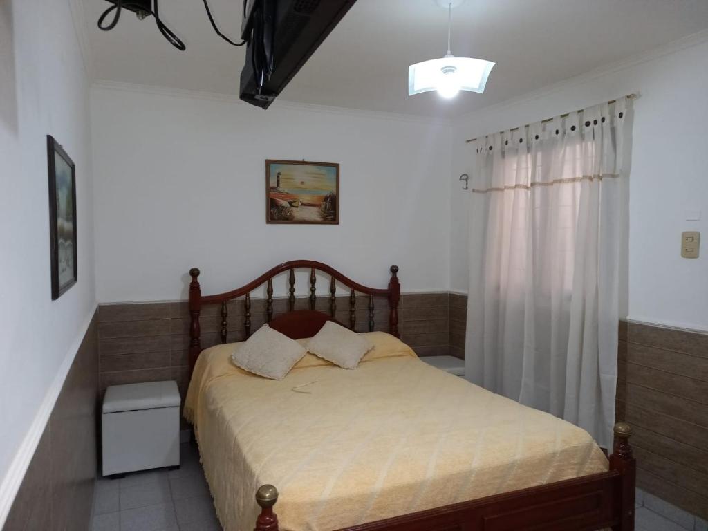 a bedroom with a bed with a wooden headboard at La juramento in San Miguel de Tucumán