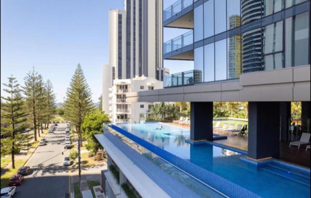 a large building with a swimming pool in a city at Beautiful Ocean View Apartment Signature Broadbeach in Gold Coast
