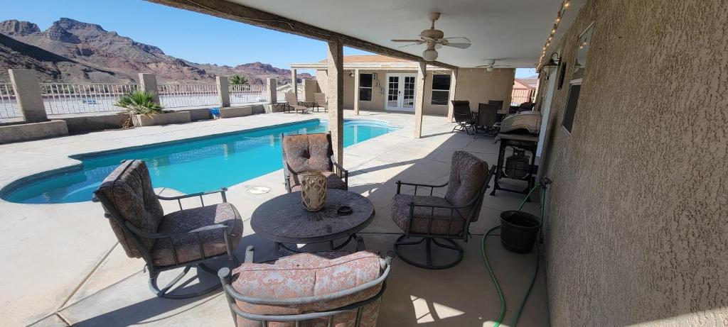 a patio with a table and chairs next to a pool at Parker Strip pool house with game room! in Parker