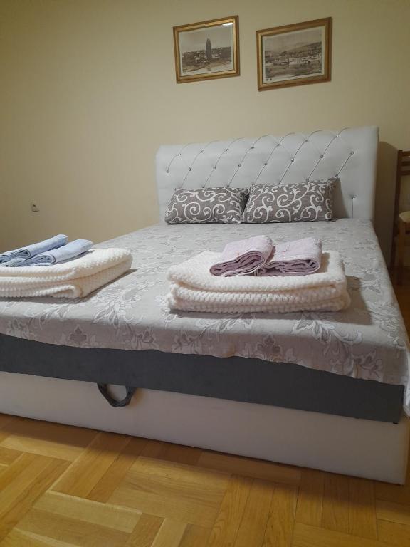 un letto bianco con due asciugamani sopra di For you apartman a Niš