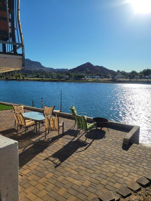 a patio with a table and chairs next to a lake at Riverfront Escape with boat dock! in Parker