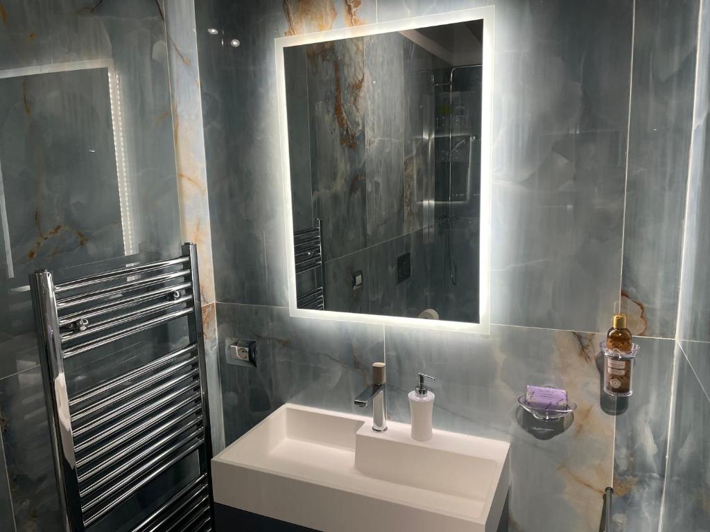 uma casa de banho com um lavatório branco e um espelho. em Suite Indipendenza 58 em Bolonha