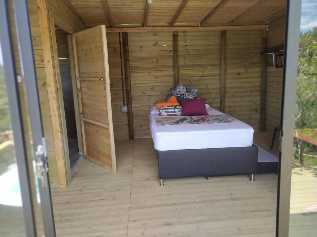 um quarto com uma cama numa casa de madeira em Natural Descanso em Carolina del Principe