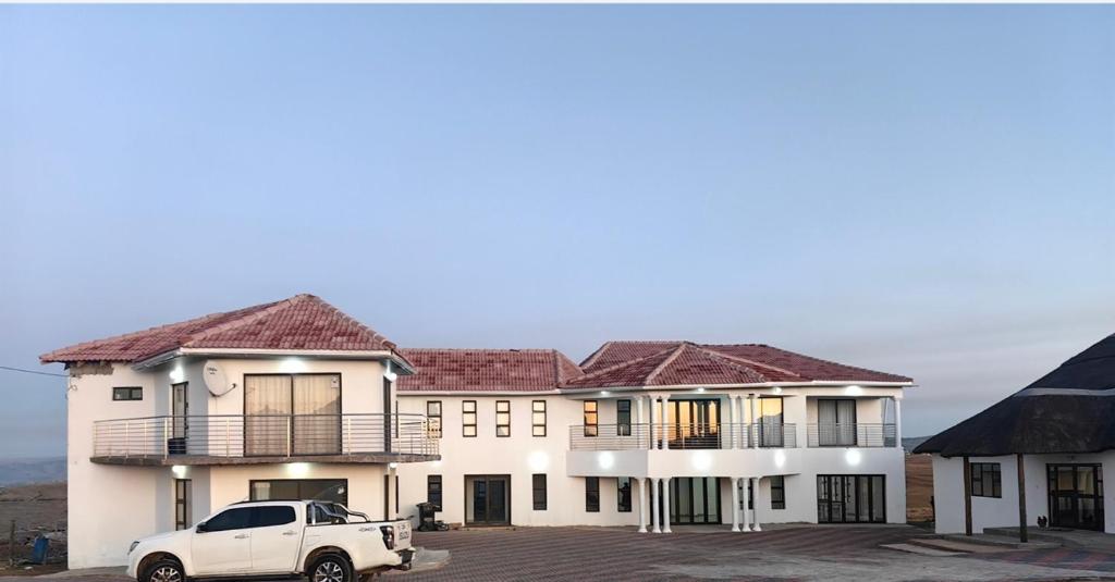 un camion bianco parcheggiato di fronte a un edificio di Ngqamakwe Luxury Guest House and Conference Centre a Nqamakwe