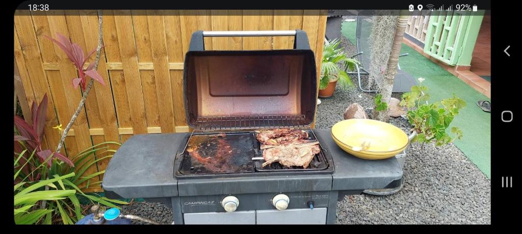 - un barbecue avec de la viande à côté d'une clôture dans l'établissement Fetay Jaune, à Baie-Mahault