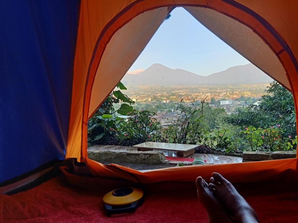 a person sitting in a tent looking out the window at Glamping ReaVeeCafe Puncak in Puncak