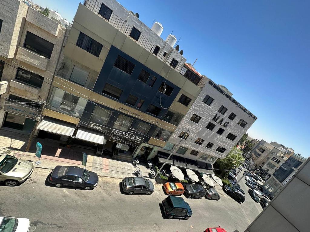 a parking lot with cars parked in front of a building at Modern 2bedroom For Rent Abdoun in Amman