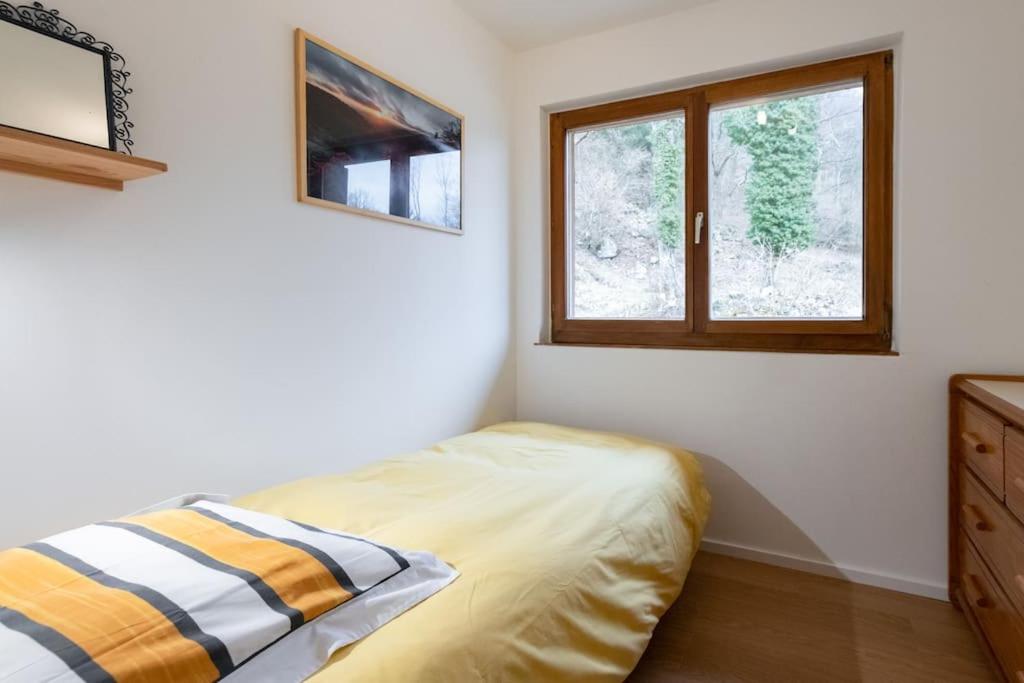a bedroom with a bed and a window at L&#39;Orée des Étoiles dans la Vallée de Munster in Stosswihr