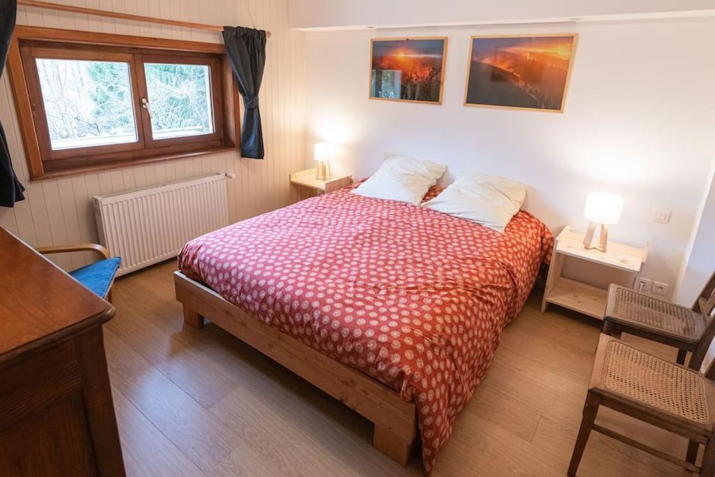 a bedroom with a bed and two tables and two windows at L&#39;Orée des Étoiles dans la Vallée de Munster in Stosswihr