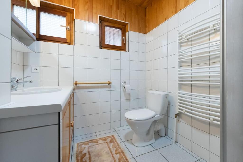 a white bathroom with a toilet and a sink at L&#39;Orée des Étoiles dans la Vallée de Munster in Stosswihr