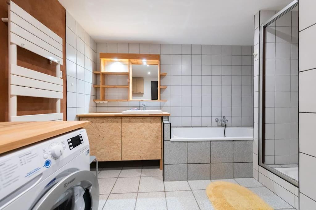 a bathroom with a sink and a washing machine at L&#39;Orée des Étoiles dans la Vallée de Munster in Stosswihr