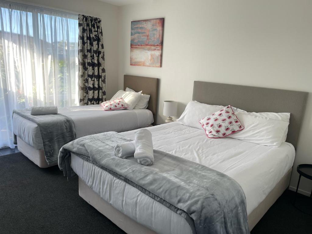 a hotel room with two beds and a window at Carters by the Sea Beachside Studio Apartments in Carters Beach
