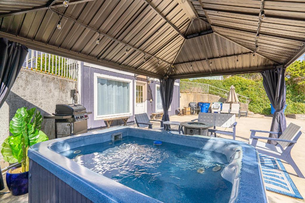 a hot tub in a patio with an umbrella at Pacific Lights in Lincoln City