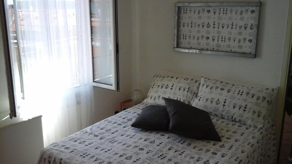 a bedroom with a bed with two pillows and a window at Sanremo Penthouse Downtown in Sanremo