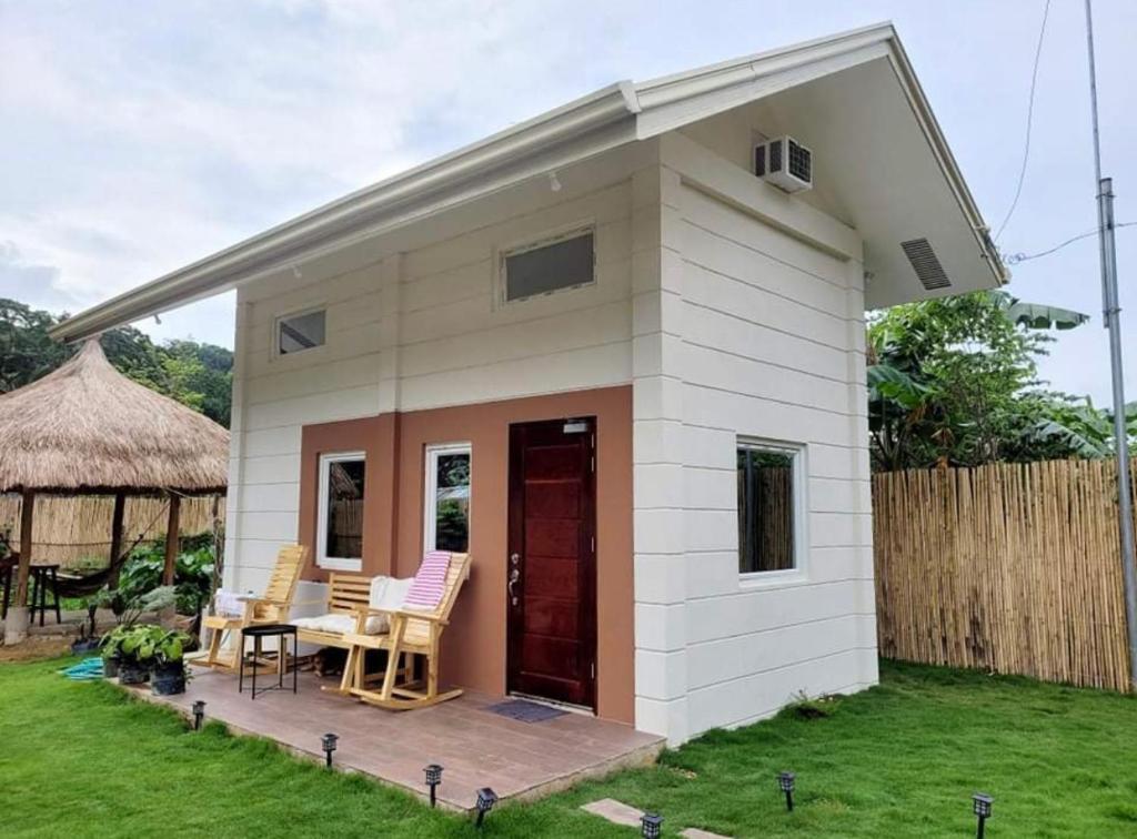 a small shed with a table and chairs in a yard at Luxury Tiny Home with Free* Use of Tiny Car in El Nido
