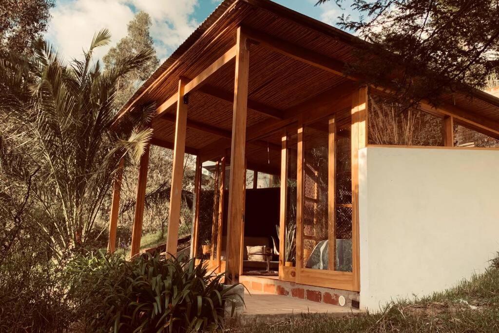 ein kleines Holzhaus mit einem großen Fenster in der Unterkunft Cozy and isolated with hot springs in Quito