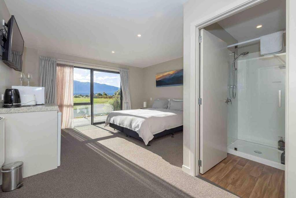 a bedroom with a bed and a sliding glass door at New Studio in Te Anau