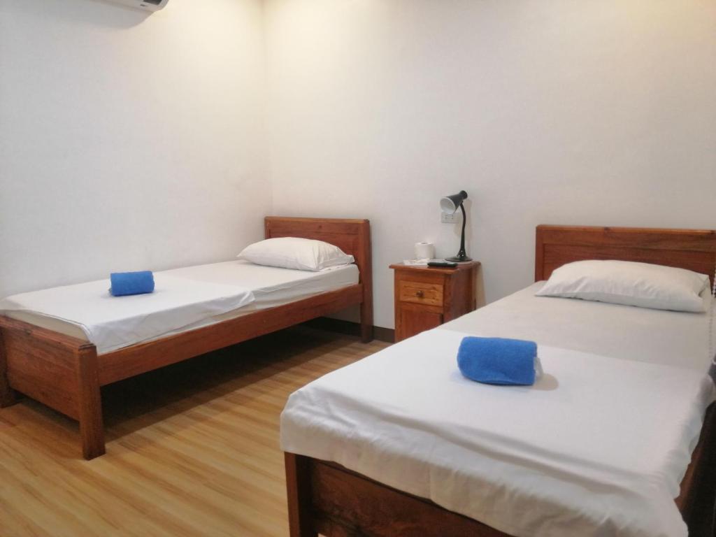 duas camas num quarto com toalhas azuis em Baki Divers and Beach Resort em Dauin