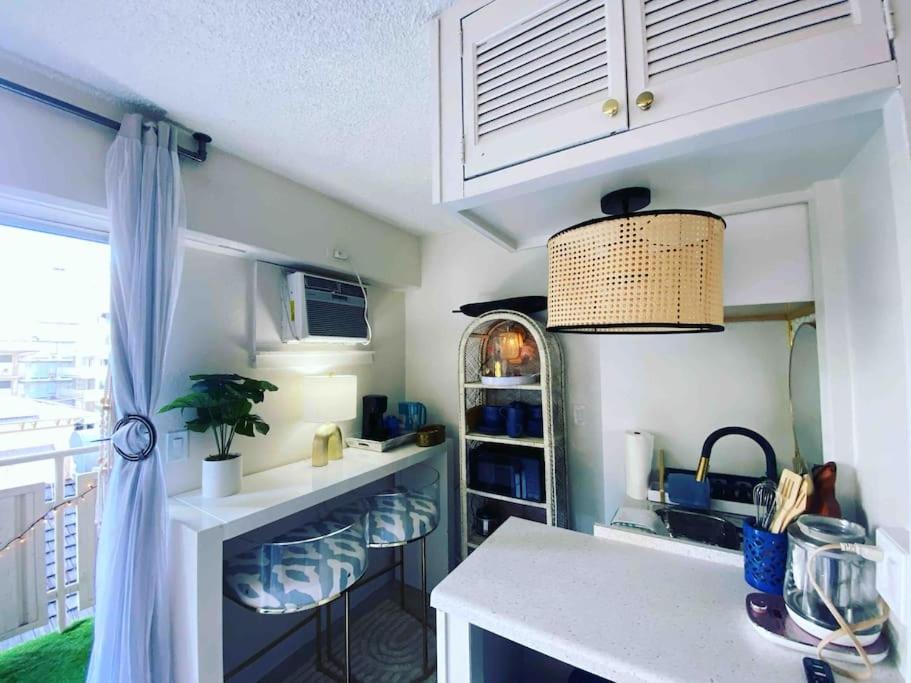 a kitchen with a sink and a counter with stools at Seashore Waikiki studio 1 block from a beach No Resort Fees in Honolulu