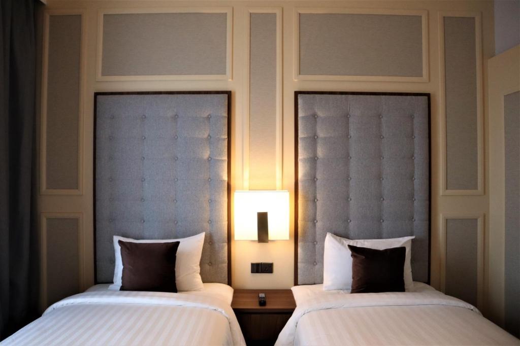 two beds sitting next to each other in a room at KSL ESPLANADE HOTEL with HOT SPRING in Klang