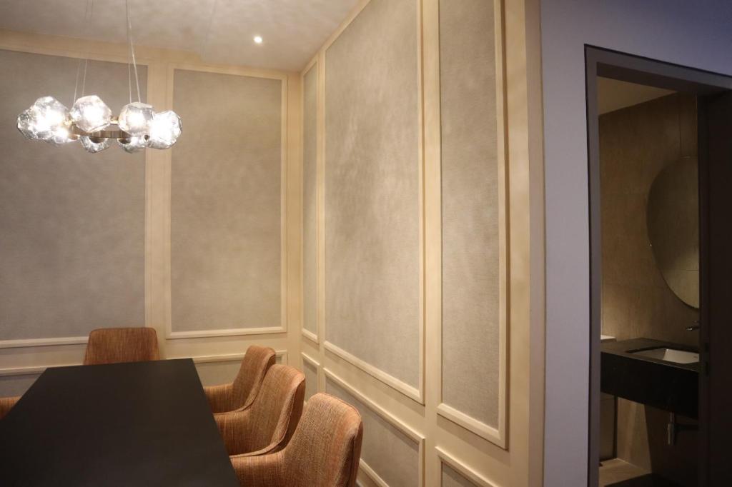 a dining room with a table and chairs and a chandelier at KSL ESPLANADE HOTEL with HOT SPRING in Klang