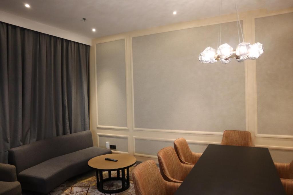 a living room with a couch and a table and chairs at KSL ESPLANADE HOTEL with HOT SPRING in Klang
