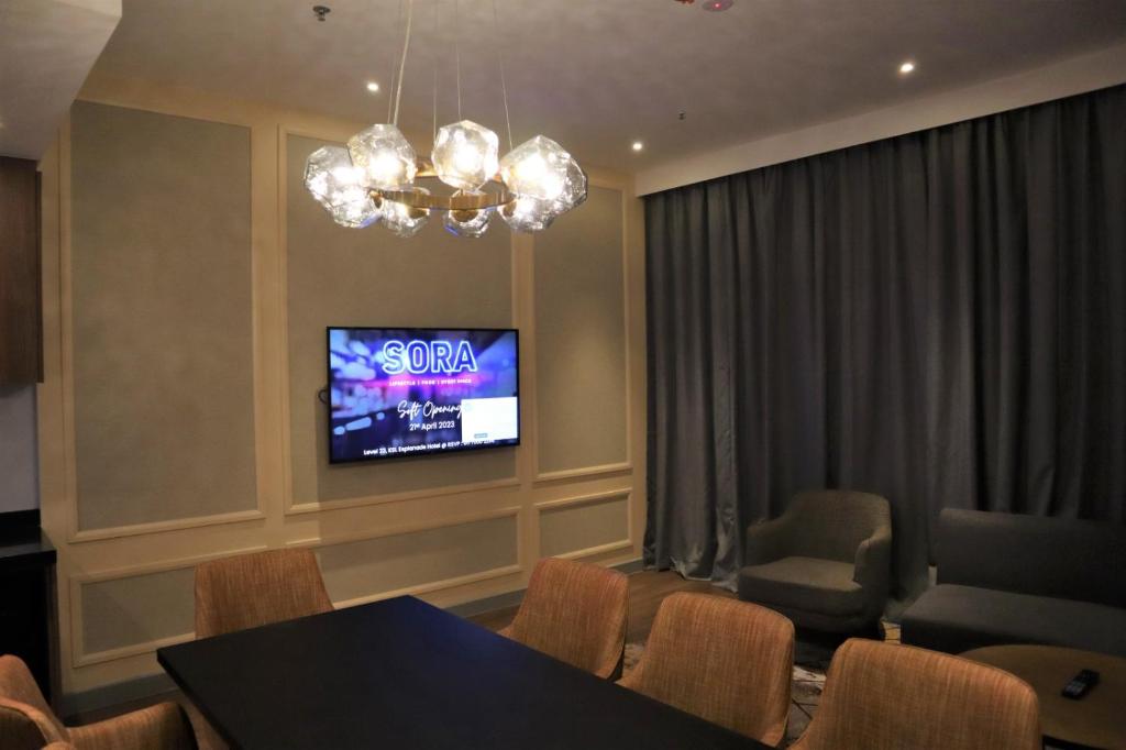 a dining room with a table and chairs and a tv at KSL ESPLANADE HOTEL with HOT SPRING in Klang