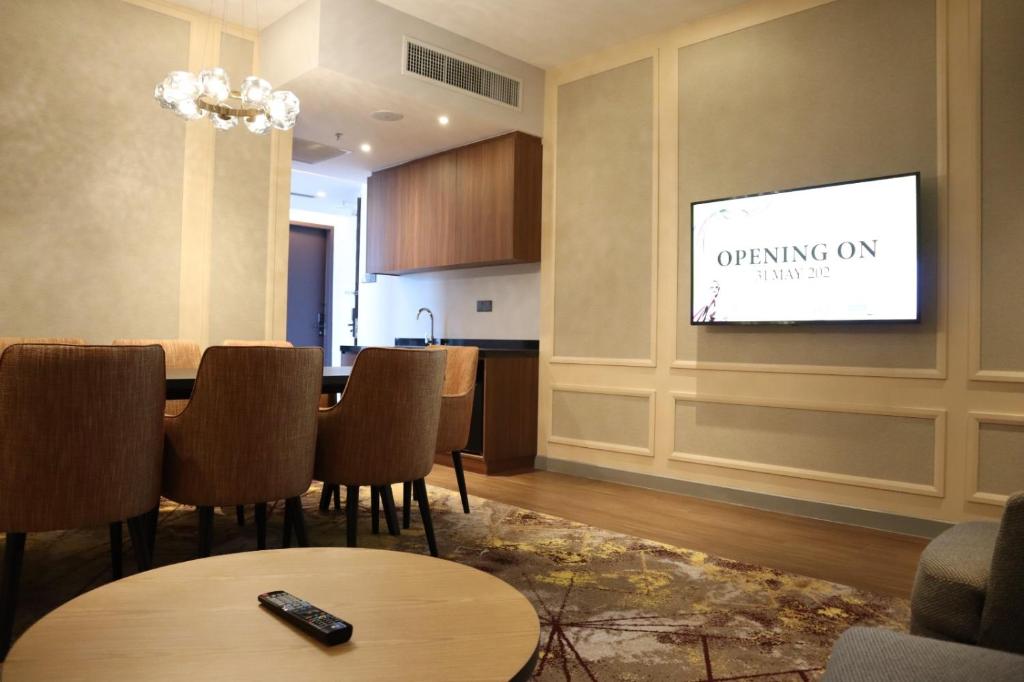 a dining room with a table and a tv on a wall at KSL ESPLANADE HOTEL with HOT SPRING in Klang
