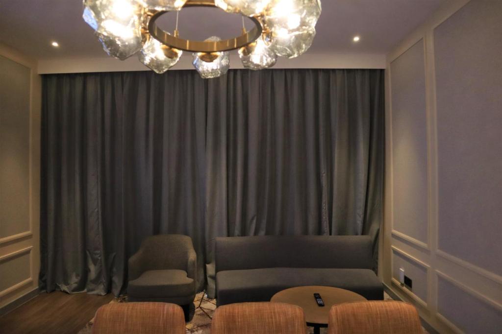 a living room with a couch and chairs and a chandelier at KSL ESPLANADE HOTEL with HOT SPRING in Klang