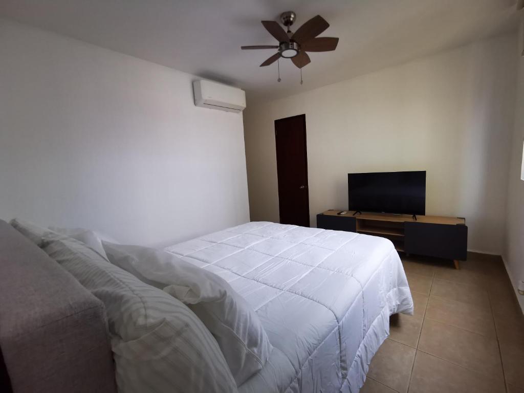 Schlafzimmer mit einem Bett und einem Flachbild-TV in der Unterkunft Habitación privada en zona exclusiva in Panama-Stadt