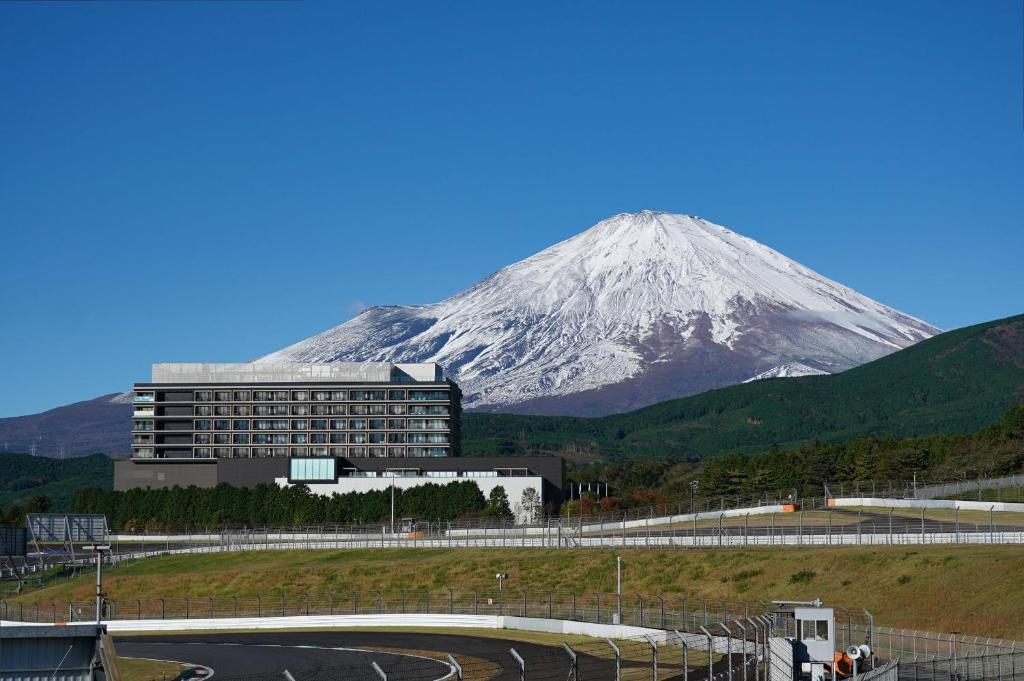 a snow covered mountain in front of a building at Fuji Speedway Hotel - The Unbound Collection by Hyatt in Oyama