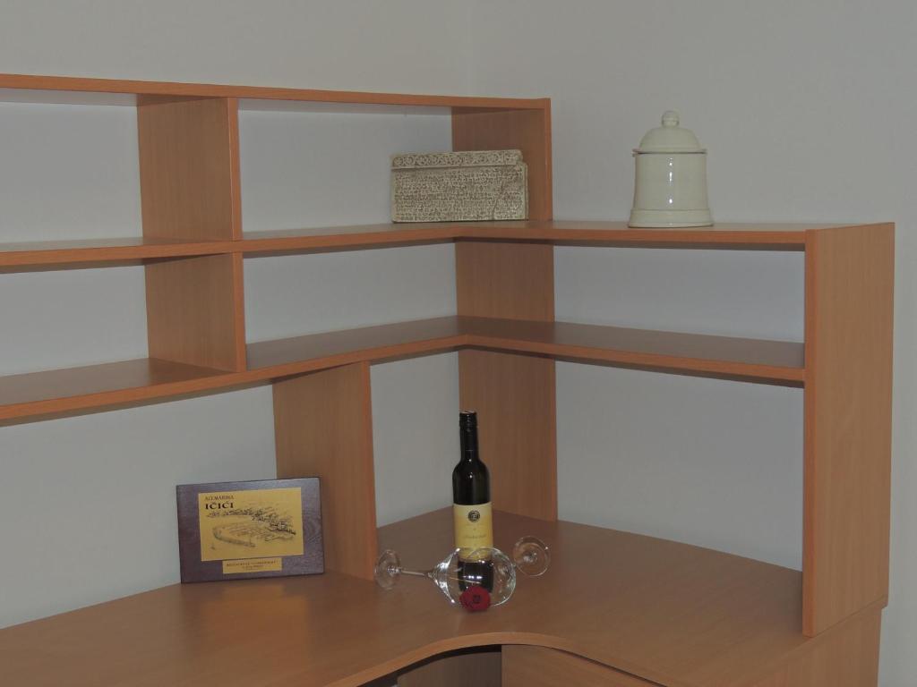 una mensola in legno con una bottiglia di vino sopra di Dolores Apartment a Opatija