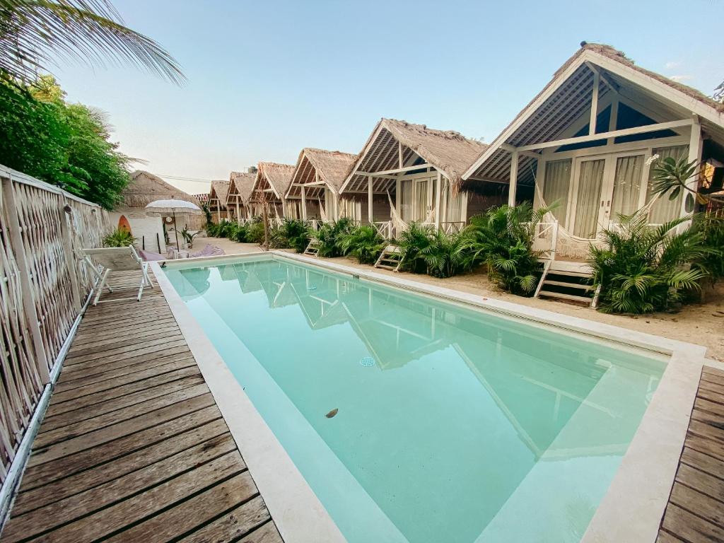 a swimming pool in front of a house at Love Coconut Bungalow in Gili Trawangan