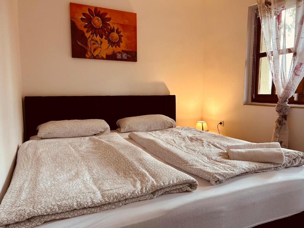 a bedroom with a bed with a white comforter at Töreki Cottage in Siófok