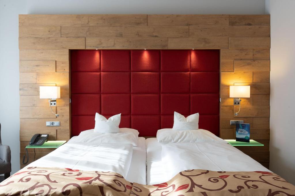 2 Betten in einem Hotelzimmer mit rotem Kopfteil in der Unterkunft Landhotel Steiner in Großheirath