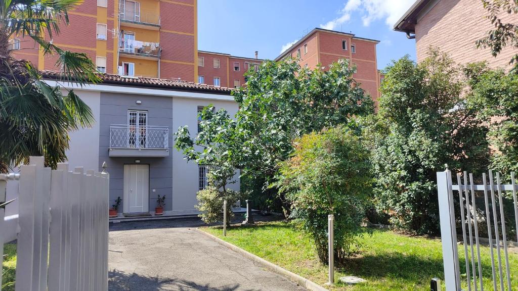 Biały dom przed budynkiem w obiekcie Grigio Perla Panigale, villetta con giardino e parcheggio privato fino a tre posti auto - Un oasi di tranqullità w Bolonii