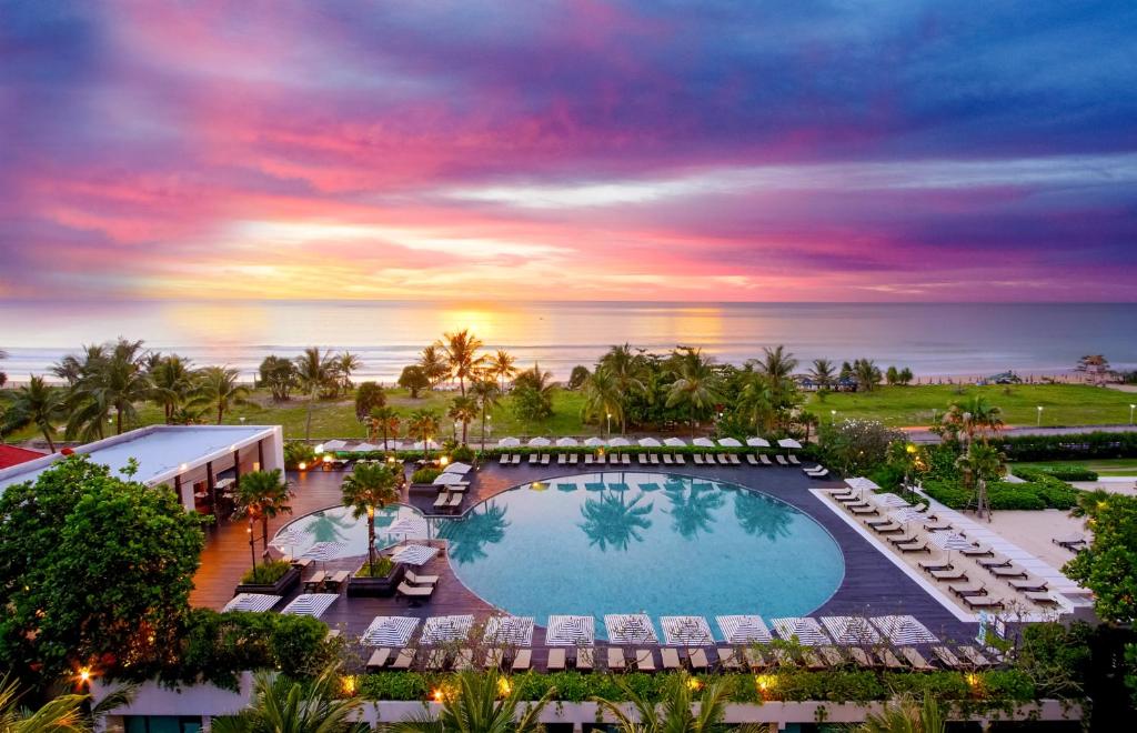 an aerial view of a resort with a pool and chairs at Pullman Phuket Karon Beach Resort in Karon Beach