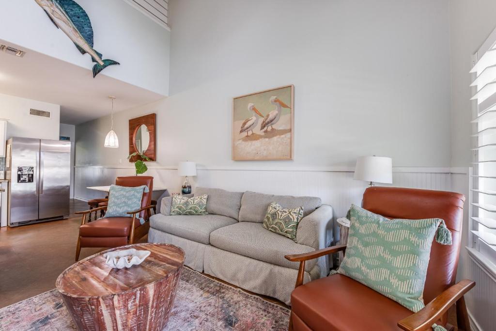 a living room with a couch and a table at Pirates Bay #118 The LUV Shack poolfront townhome in Port Aransas