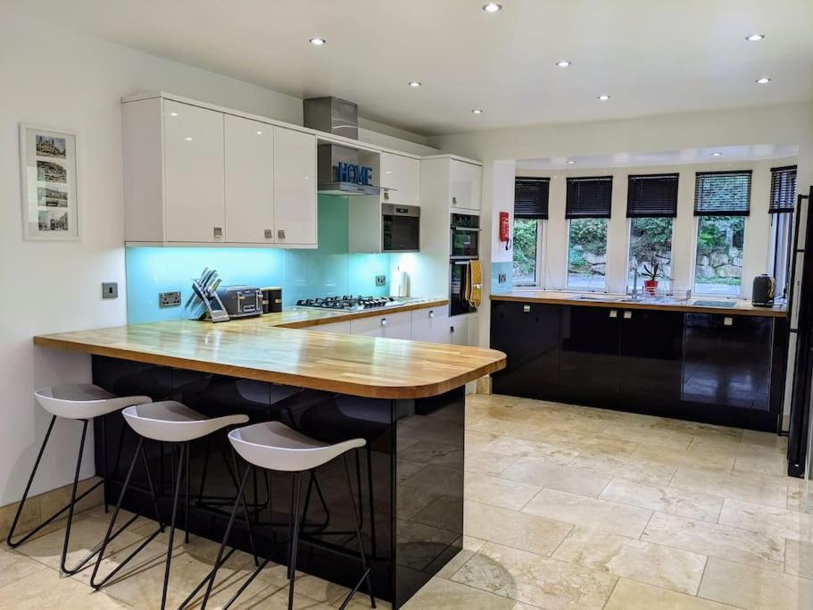 a kitchen with a wooden counter and stools in it at Detached 4 Bedroom Luxury Home in Halifax